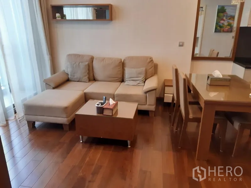 คอนโด ให้เช่าในWatthana, Bangkok - ห้องนั่งเล่นพื้นไม้ โซฟาแอลสีเบจ โต๊ะกลาง และหน้าต่างบานใหญ่ติดกับพื้นที่ทานอาหาร