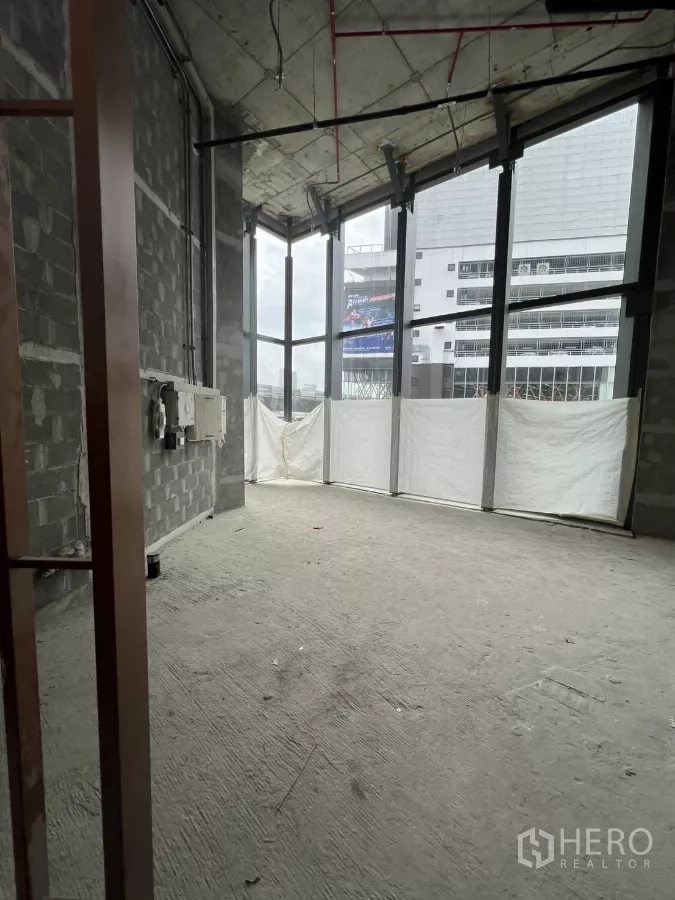 พื้นที่ขายปลีก ให้เช่า - พื้นที่ค้าปลีกสภาพเปลือย เพดานโชว์งานระบบ พื้นคอนกรีต และกระจกมุมสูงโปร่งมองเห็นวิวเมือง