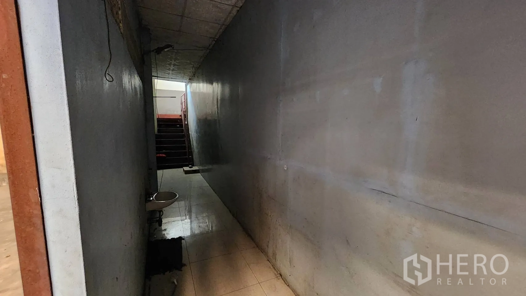 货栈 出租在Nonthaburi - 狭长内走廊带洗手盆，通向楼梯。