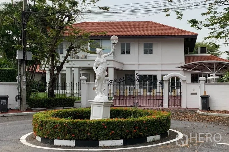 独立式住宅 出租在Bang Phli, Samut Prakan - 从景观环岛处看到的房子正面，设有经典雕像与庭院大门。