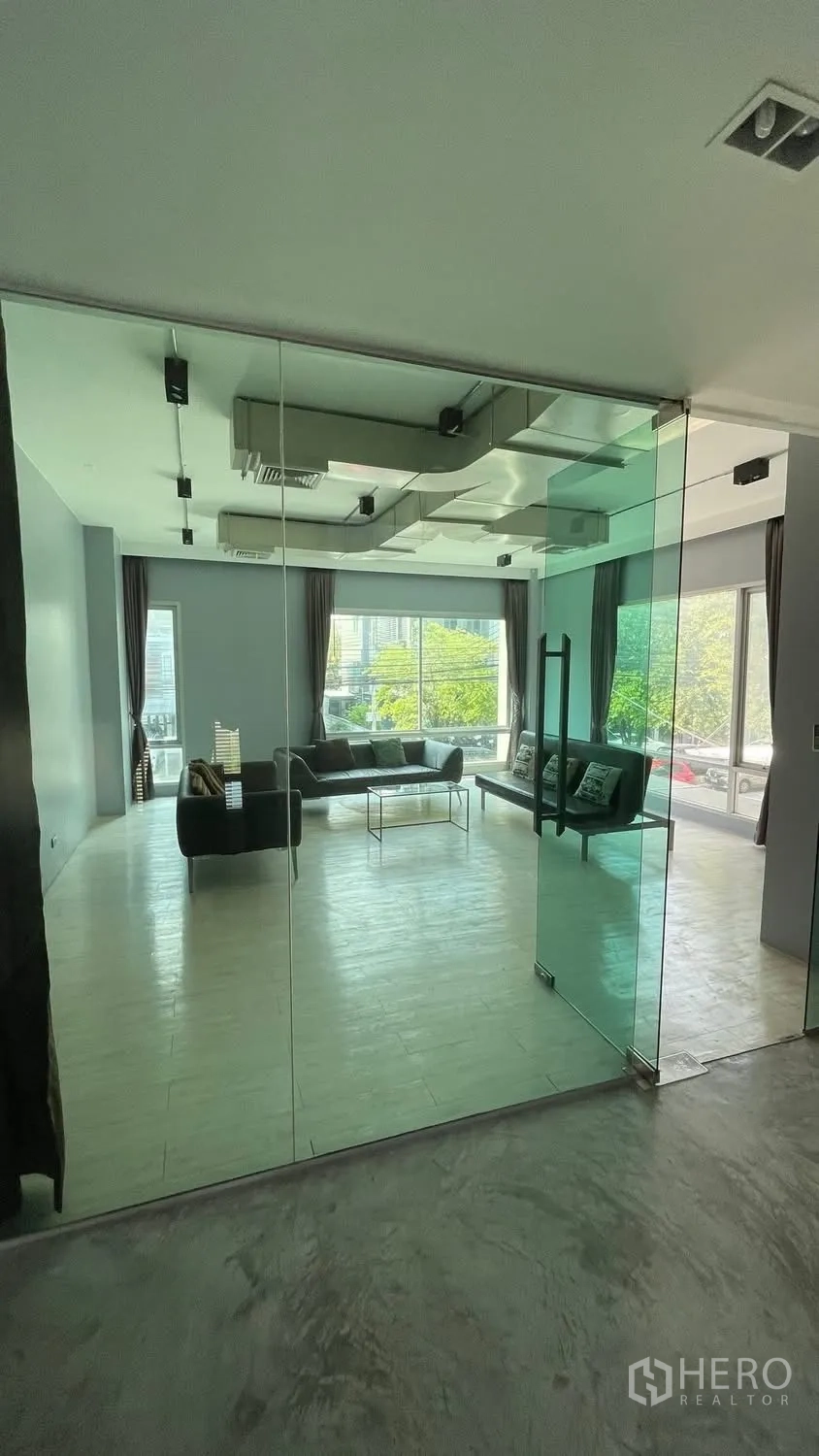 家庭办公室 for rent or sale in Wang Thonglang, Bangkok - 通过落地玻璃隔断可见的宽敞房间和大窗户。