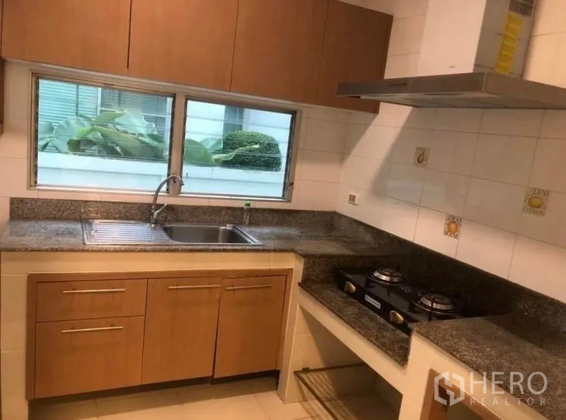Detached House for rent in Prawet, Bangkok - Fitted kitchen with granite countertops, double gas hob, range hood and sink.