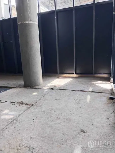 พื้นที่ขายปลีก ให้เช่าในWatthana, Bangkok - บริเวณทางเข้าชั้นล่าง เสากลม แผงเหล็ก และพื้นคอนกรีตดิบ