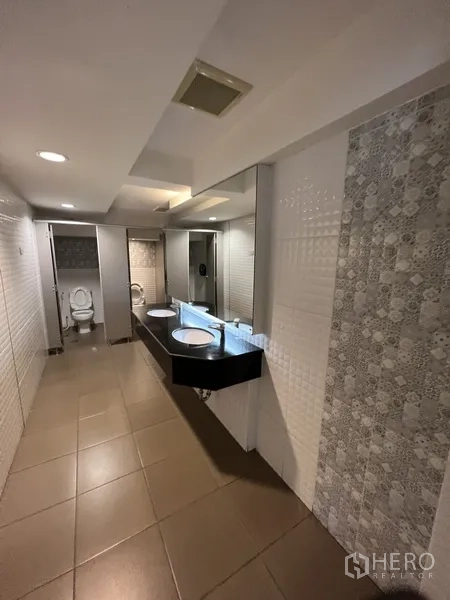 零售空间 出租在Huai Khwang, Bangkok - 公共洗手间，双台盆、瓷砖墙面与多间隔间。