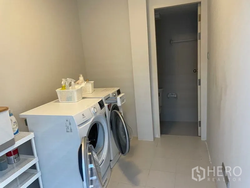 联排别墅 出售在Lat Phrao, Bangkok - 洗衣房配滚筒洗衣机、烘干机与收纳架。