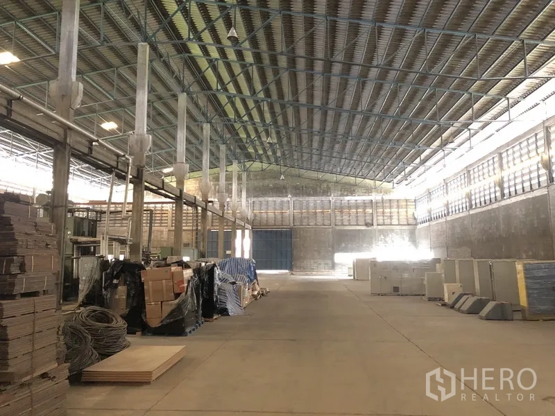 工厂 出租在Bang Bua Thong, Nonthaburi - 仓储区，材料堆放、宽中央通道与卷帘大门
