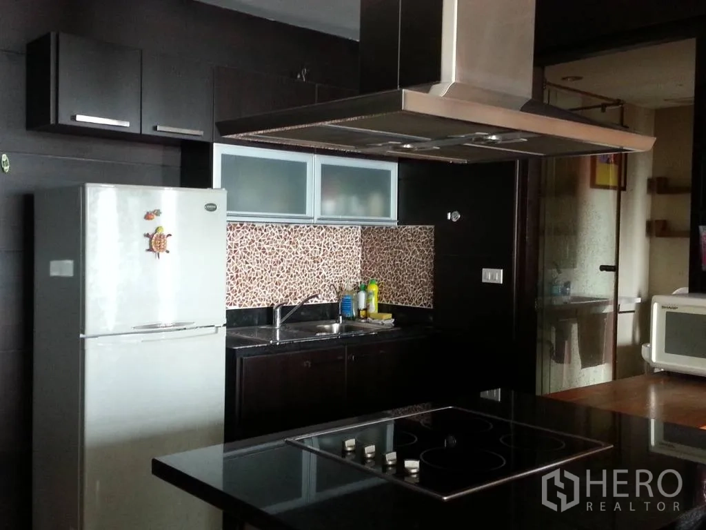 คอนโด ให้เช่าในKhlong San, Bangkok - ครัวปิดตู้สีเข้ม ผนังกระเบื้องลายโมเสก เครื่องดูดควันสเตนเลสและเตาไฟฟ้า