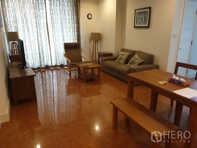 คอนโด ให้เช่าหรือขายในKhlong Toei, Bangkok - ห้องนั่งเล่นสว่างพร้อมทีวี โซฟาผ้า เก้าอี้พักผ่อน และผ้าม่านเต็มความสูง.