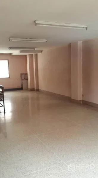 店屋 出租在Bang Khen, Bangkok - 楼上开放式房间，水磨石地面、日光灯与结构立柱。