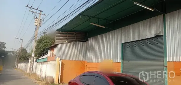 货栈 出租在Bueng Kum, Bangkok - 仓库外立面位于街边，波纹金属墙面、绿色雨棚与大卷帘门，曼谷Bueng Kum。