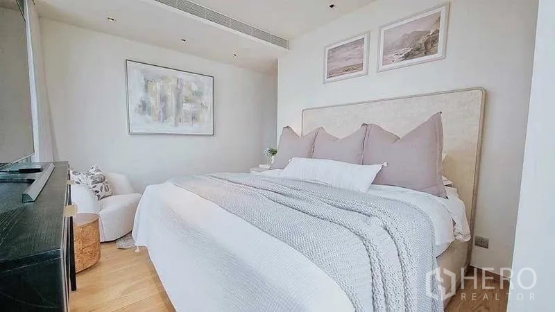 คอนโด ขาย - ห้องนอนสว่าง เตียงบุผ้า ชุดเครื่องนอนโทนอ่อน และภาพศิลป์มินิมอล