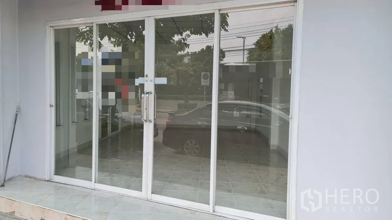 Shophouse for rent - Close-up of sliding glass doors reflecting the street scene