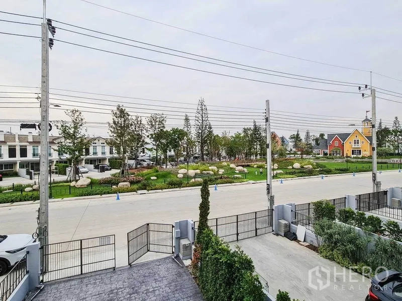 联排别墅 出租在Prawet, Bangkok - 从家中望向景观公园与设门禁的联排街区。