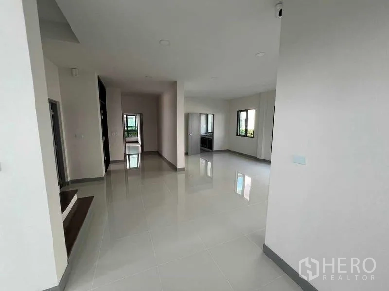 Detached House for rent in Khlong Sam Wa, Bangkok - Open-plan ground floor with white tiles, several windows and access to the kitchen.