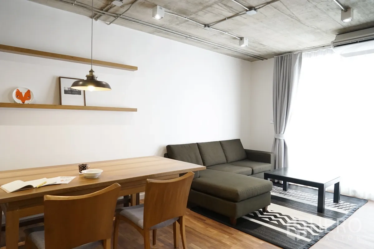 คอนโด ให้เช่าในWatthana, Bangkok - ห้องนั่งเล่น–รับประทานอาหารสว่าง โซฟาเข้ามุม โต๊ะไม้ โคมแขวน และผ้าม่านสูงจรดเพดาน