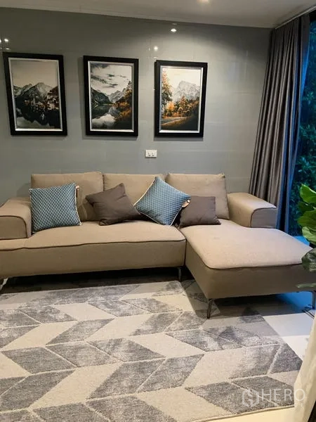 ทาวน์เฮาส์ ให้เช่าในSuan Luang, Bangkok - ห้องนั่งเล่นที่สอง โซฟาเบจทรงแอล พรมลายเรขาคณิต และภาพติดผนังใกล้หน้าต่างบานใหญ่