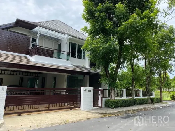 Detached House for rent in Prawet, Bangkok - Modern two-storey detached house with gated carport and tree-lined street in a secure compound.