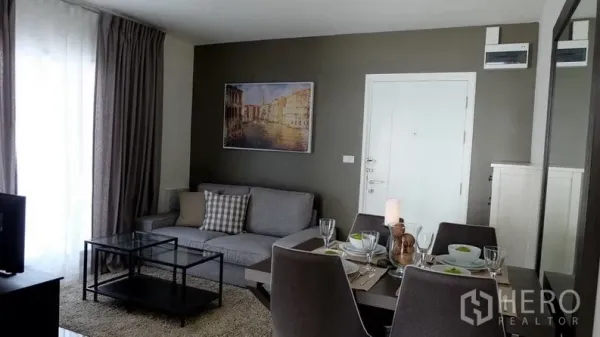 公寓 出售在Khlong Toei, Bangkok - 开放式客厅与餐厅，灰色沙发、玻璃桌与落地窗帘，曼谷待租公寓。