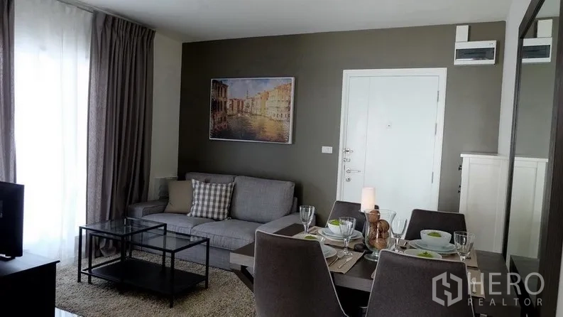 公寓 出售在Khlong Toei, Bangkok - 开放式客厅与餐厅，灰色沙发、玻璃桌与落地窗帘，曼谷待租公寓。