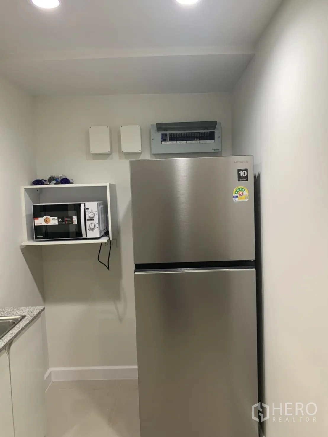 联排别墅 for rent in Bang Kapi, Bangkok - 紧凑厨房配不锈钢双门冰箱与微波炉搁架。