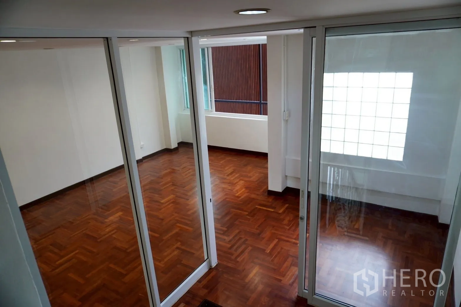 带办公室的家 for rent in Watthana, Bangkok - 通过玻璃隔断看到相连房间与木地板。