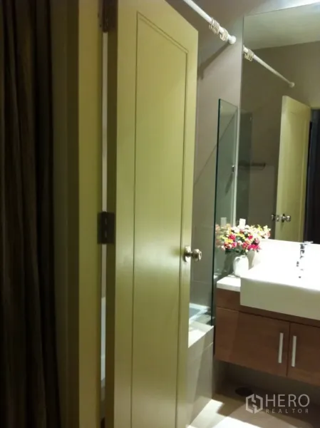 Condominium for rent or sale in Watthana, Bangkok - Contemporary bathroom with large mirror, vanity cabinet, vessel sink and glass shower screen.