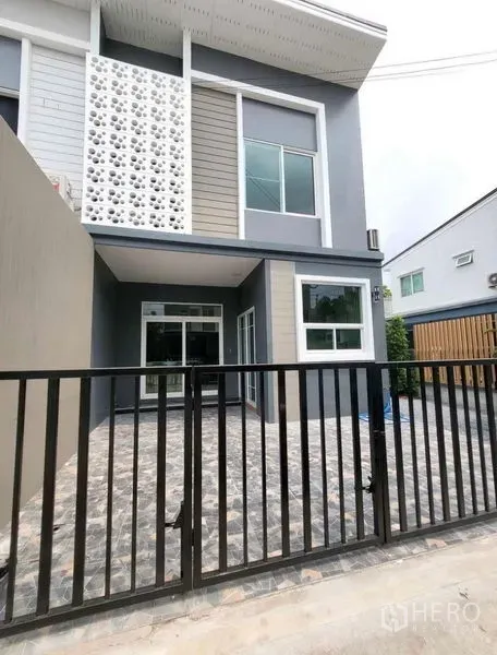 Townhouse for rent or sale - Two-storey townhouse exterior with gated carport, modern façade and sliding glass doors.