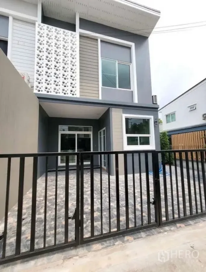 Townhouse for rent or sale - Two-storey townhouse exterior with gated carport, modern façade and sliding glass doors.