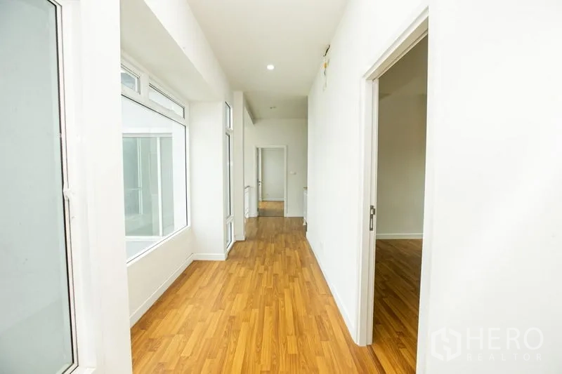 บ้าน ให้เช่าหรือขายในLam Luk Ka, Pathum Thani - มุมมองหน้าบ้านกว้าง มีทางรถเข้า ประตูรั้ว และแนวพุ่มไม้จัดสวน