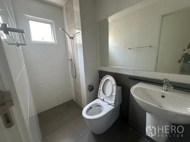 带办公室的家 出租在Bang Na, Bangkok - 干净的卫生间，带淋浴、坐便、洗手盆和大镜子。