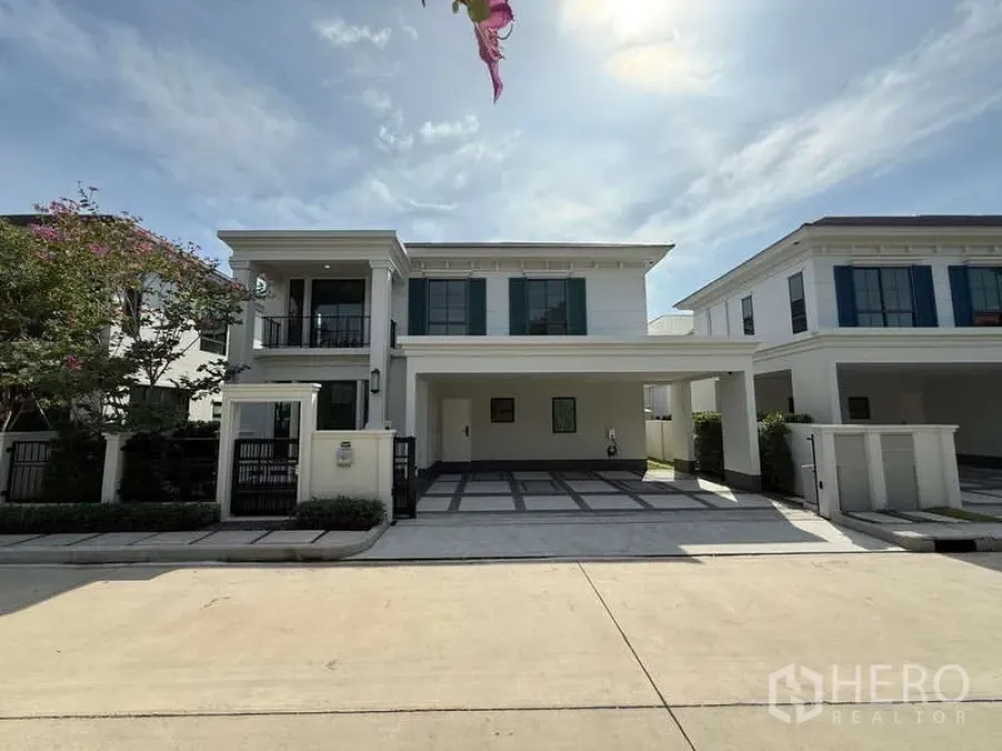 Detached House for rent or sale in Bang Phli, Samut Prakan - Street-side view of the house in a gated community under a clear sky.