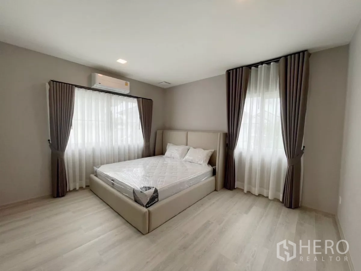 Detached House for rent in Bang Phli, Samut Prakan - Spacious corner bedroom with large windows and soft gray curtains.