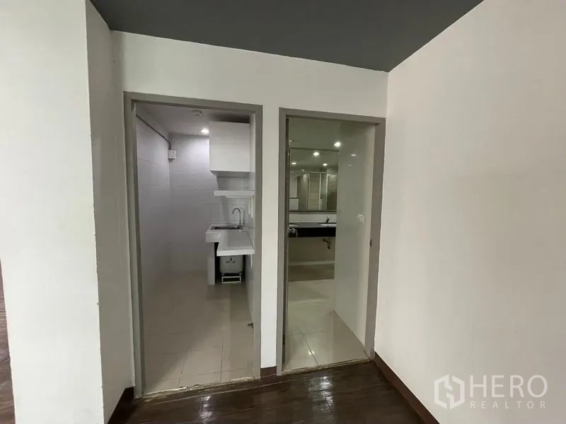 办公空间 出租在Ratchathewi, Bangkok - 办公室内的小茶水间与洗手间入口，带水槽和瓷砖地面。