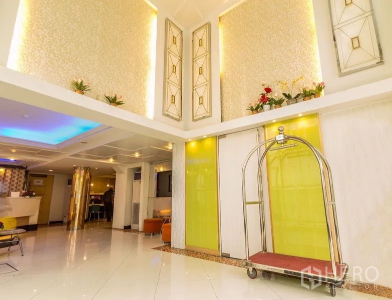 พื้นที่ขายปลีก ให้เช่า - โถงเพดานสูงสองชั้น แผงตกแต่ง และรถเข็นสัมภาระใกล้ประตูเลื่อน