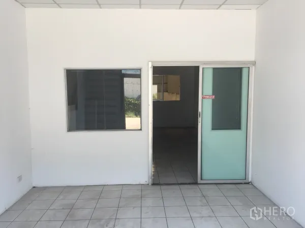 工厂 出租在Khlong Luang, Pathum Thani - 一层办公室入口，推拉玻璃门与地砖地面。