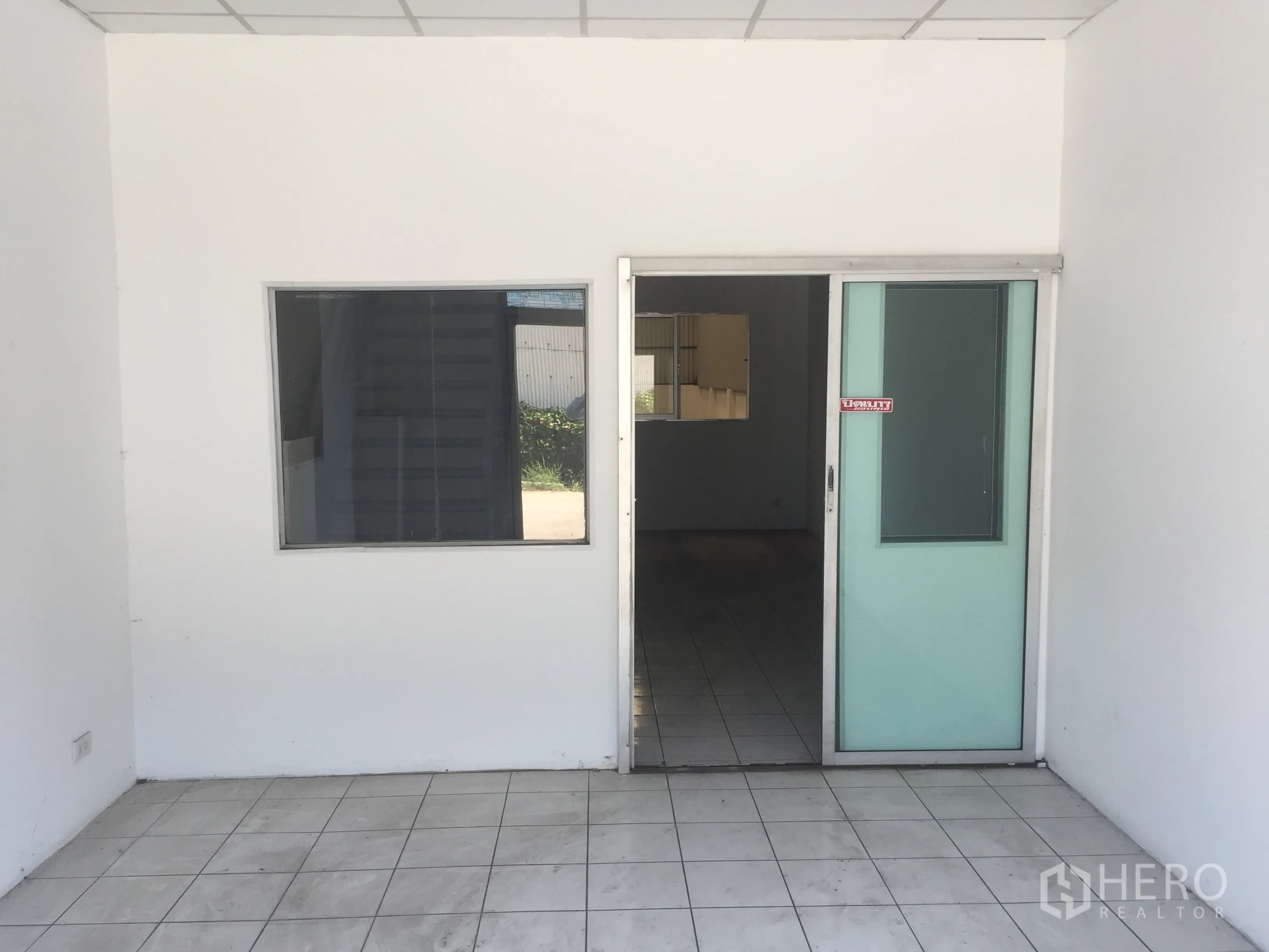 工厂 出租在Khlong Luang, Pathum Thani - 一层办公室入口，推拉玻璃门与地砖地面。