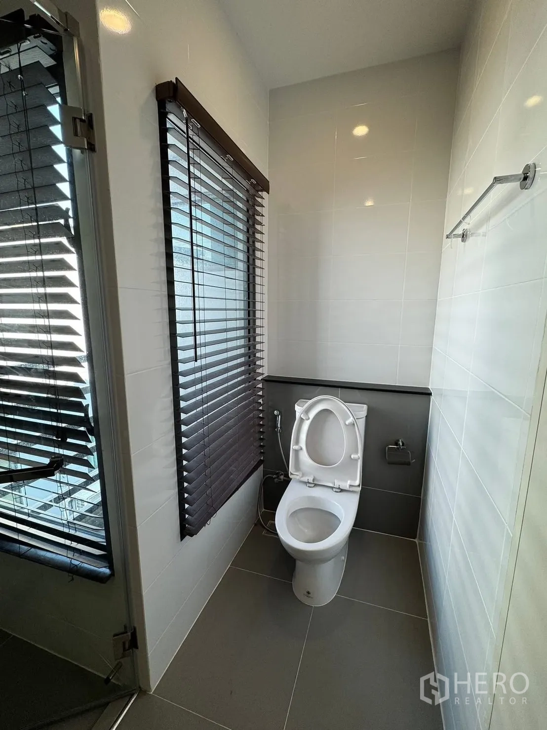 Townhouse for rent in Saphan Sung, Bangkok - Bright bathroom with window blinds, toilet and glass shower.