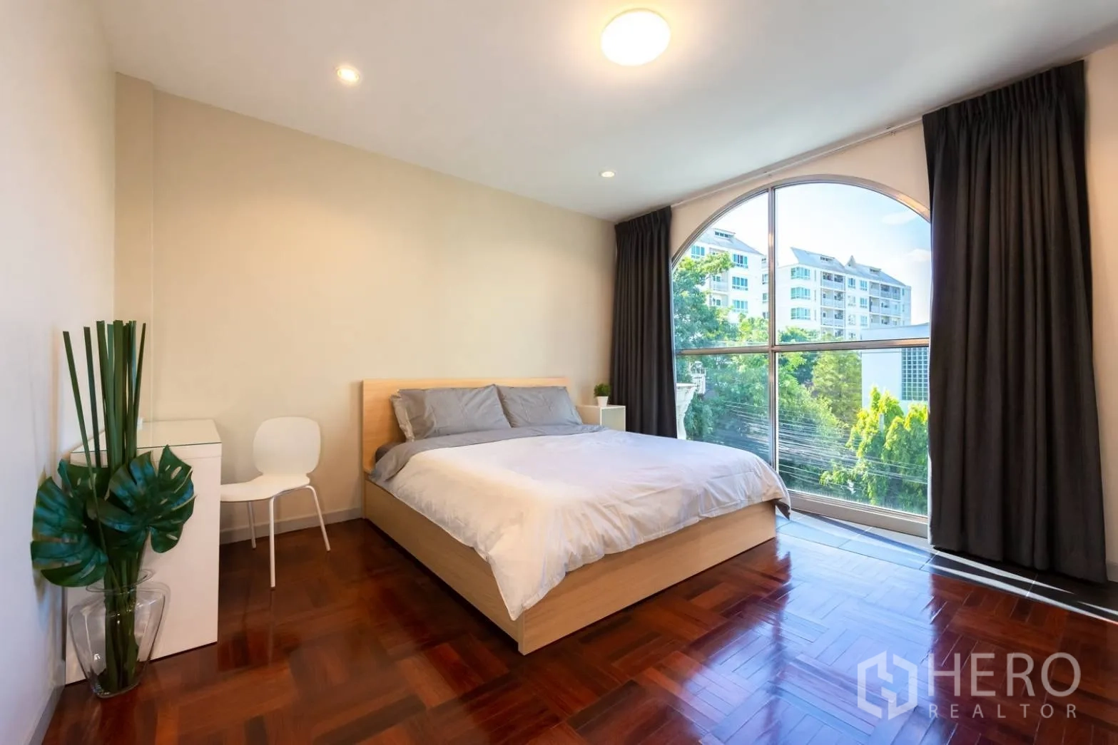 带办公室的家 出租在Bang Rak, Bangkok - 卧室配拱形大窗，园景视野与亮面木地板。