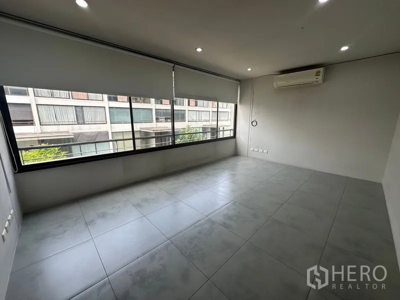 Home Office for rent in Phra Khanong, Bangkok - Spacious office or bedroom with a wide window, gray tiles and wall AC.