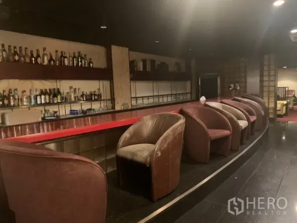 零售空间 出租在Bang Rak, Bangkok - 红色长吧台，背墙设瓶架，配绒面吧椅。