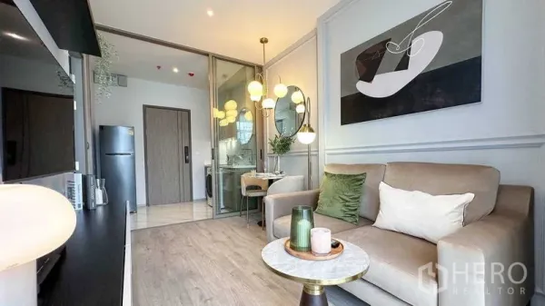 คอนโด ให้เช่าในWatthana, Bangkok - พื้นที่นั่งเล่นมองไปยังครัวกะทัดรัดหลังประตูกระจกบานเลื่อน มุมทานอาหารลายหินอ่อนและงานศิลป์