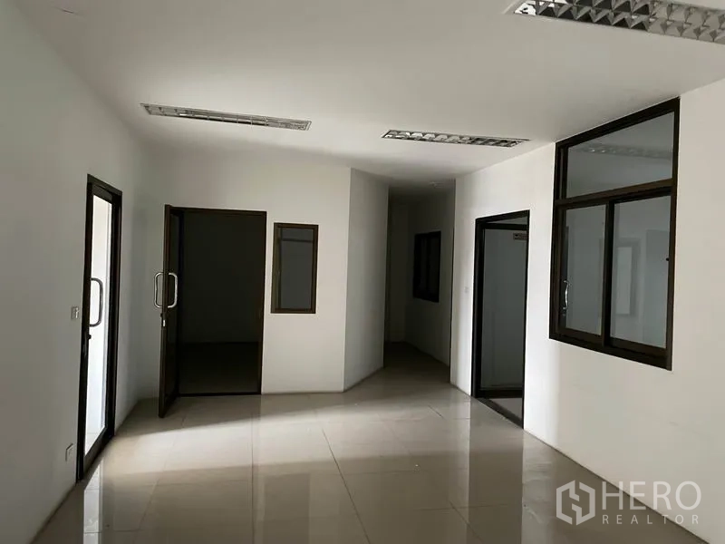 货栈 出租在Prawet, Bangkok - 仓库内的办公房间，瓷砖地面、玻璃窗与日光灯。