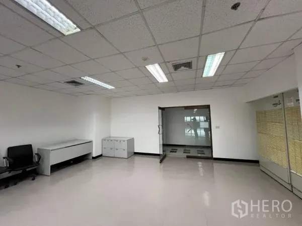 Office Space for rent or sale - Reception or team area with glass entry door, built-in storage cabinets, and overhead lighting.