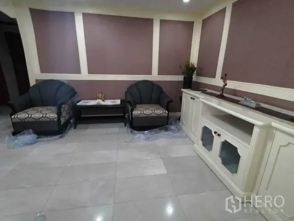 Condominium for rent in Watthana, Bangkok - Lounge area with two armchairs, built-in console and tiled floor in a Bangkok condo.