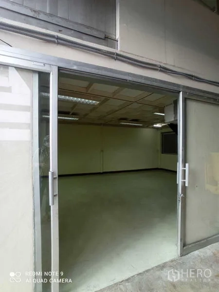 Warehouse for rent in Suan Luang, Bangkok - Glass sliding door opening into a clean office room inside the warehouse.