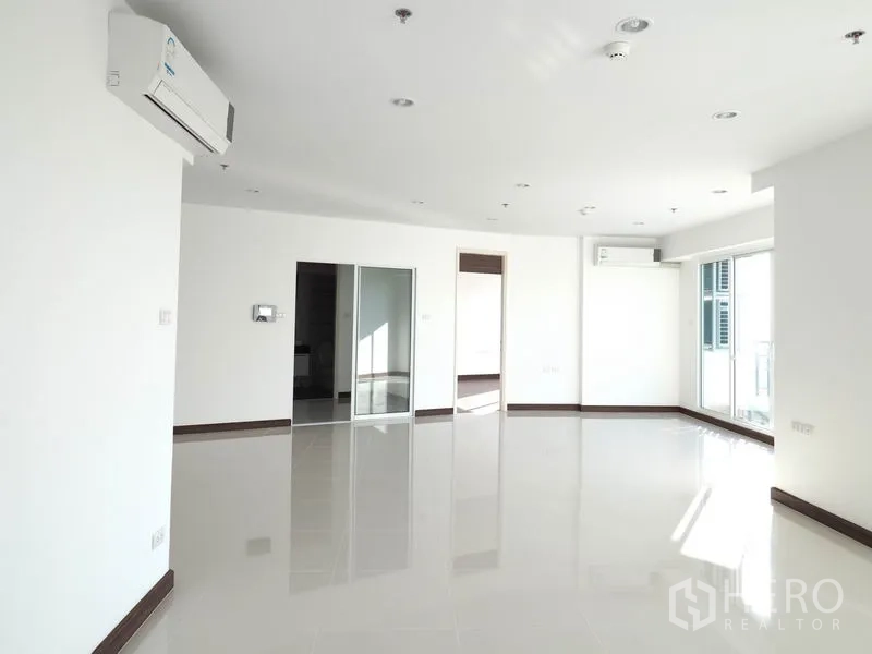 Condominium for rent in Yan Nawa, Bangkok - Sunlit open-plan living and dining area with air conditioners, glossy tiles and multiple doorways.