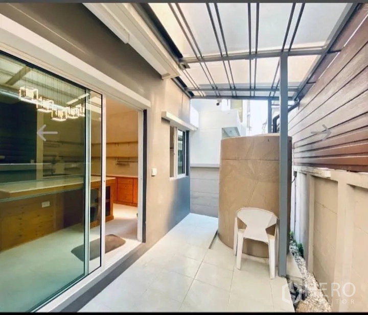 Detached House for sale in Saphan Sung, Bangkok - Covered side patio with tiled floor, sliding glass doors and a water tank.