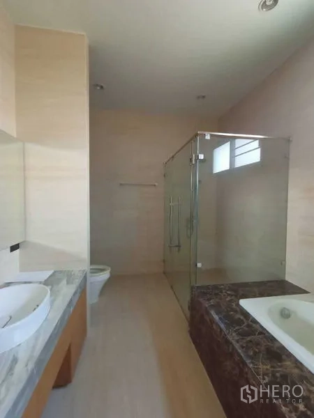 Home Office for rent in Watthana, Bangkok - Spacious bathroom with glass shower, marble tub surround and long vanity.