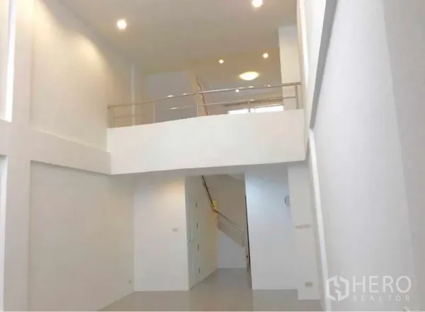 Home Office for rent in Wang Thonglang, Bangkok - Double-height lobby with white walls, mezzanine level and recessed lighting leading to a staircase.