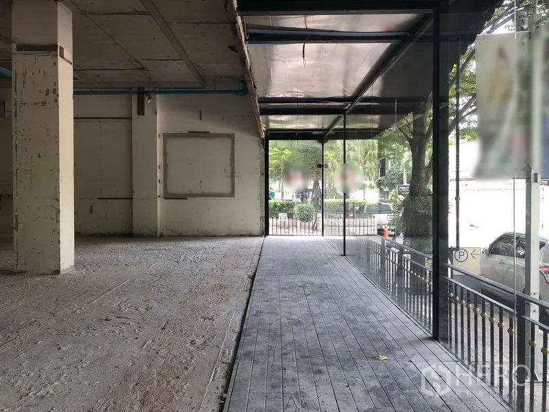 零售空间 出租在Watthana, Bangkok - 宽敞室内，落地玻璃与通往入口的抬高步道。